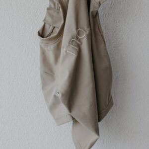 An Ina Rash Shirt hanging on a white wall.