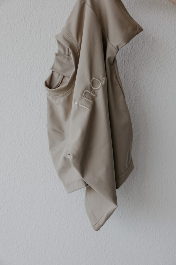 An Ina Rash Shirt hanging on a white wall.