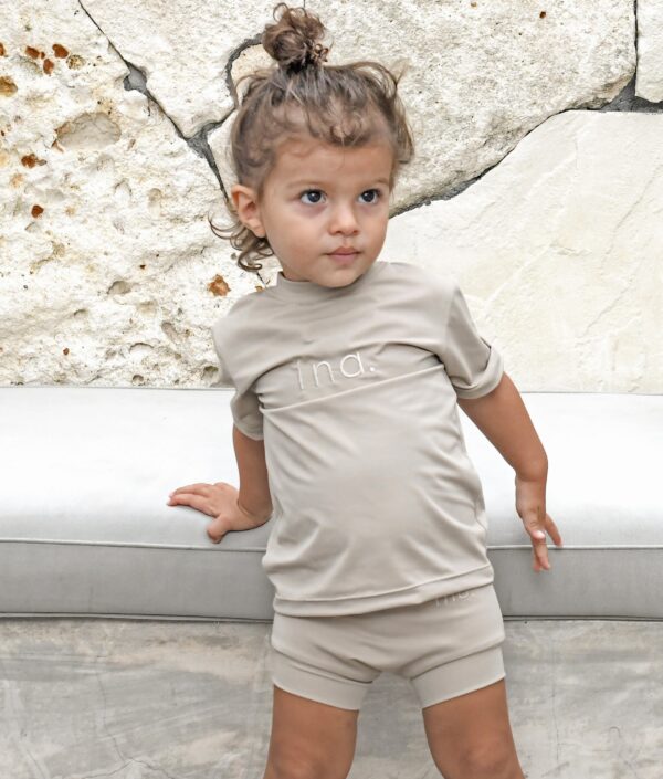 A little girl wearing an Ina Rash Shirt and shorts.