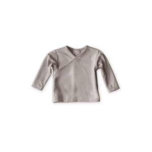 A plain, long-sleeved, Ada Rash Shirt in sand colour laid out on a white background.