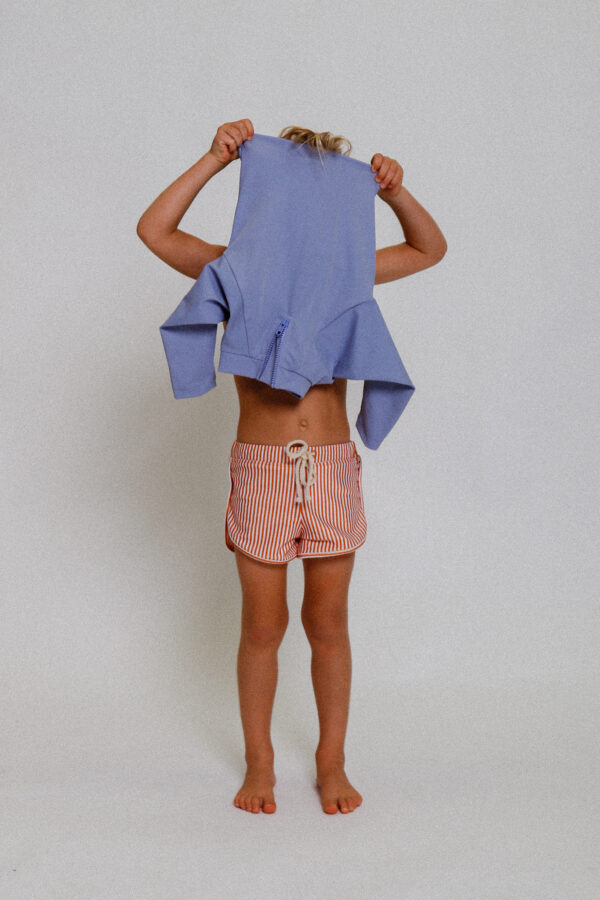 A little girl wearing the Playtime Collection - Nella Rash Shirt - Mandarin shorts.