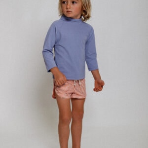 A young boy in a Playtime Collection - Nella Rash Shirt - Mandarin and pink shorts.