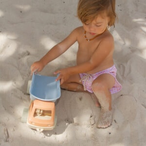 A little girl playing with Azure and Apricot Gingham - Mesa Trunks in the sand.