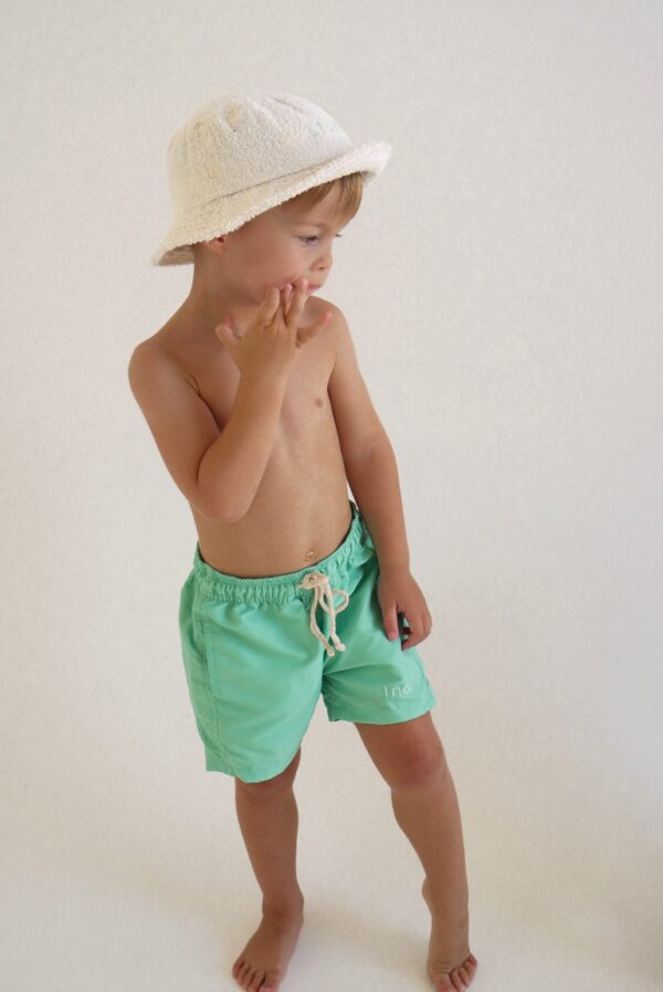 A young boy wearing Sorbet Summer - Sea Shorts and a white hat.