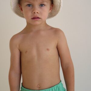 A young boy wearing a white hat and Sorbet Summer - Sea Shorts.