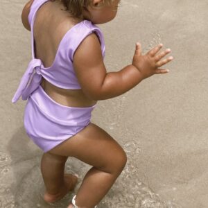 A little girl in a Sorbet Summer - Arla Bikini - Grape Colour playing in the sand.