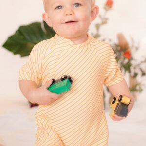 A baby in a yellow striped Retro Wave By Ina - Zimmi Onesie holding a toy car.