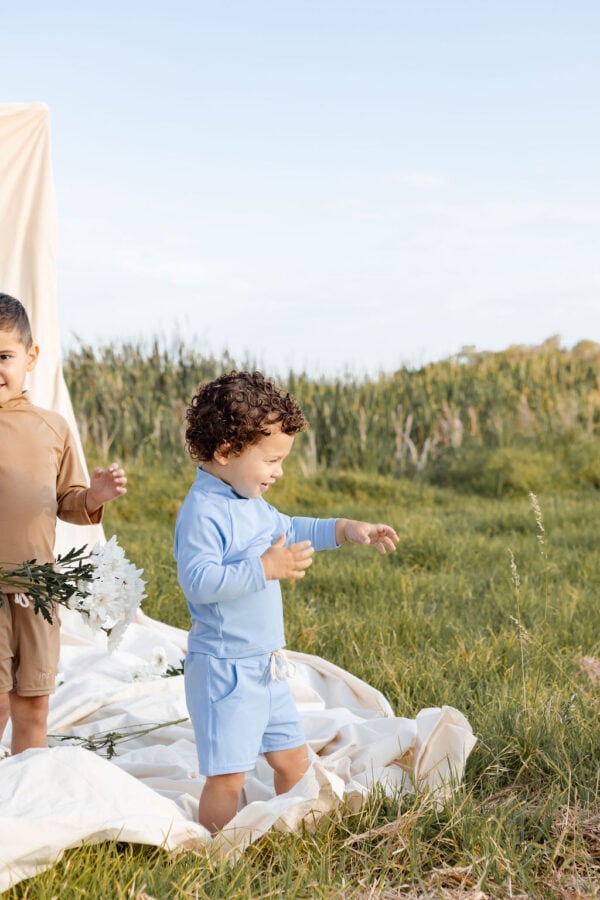Two children standing on a WS - Golden Meadows Collection - Amias Trunks in a field.