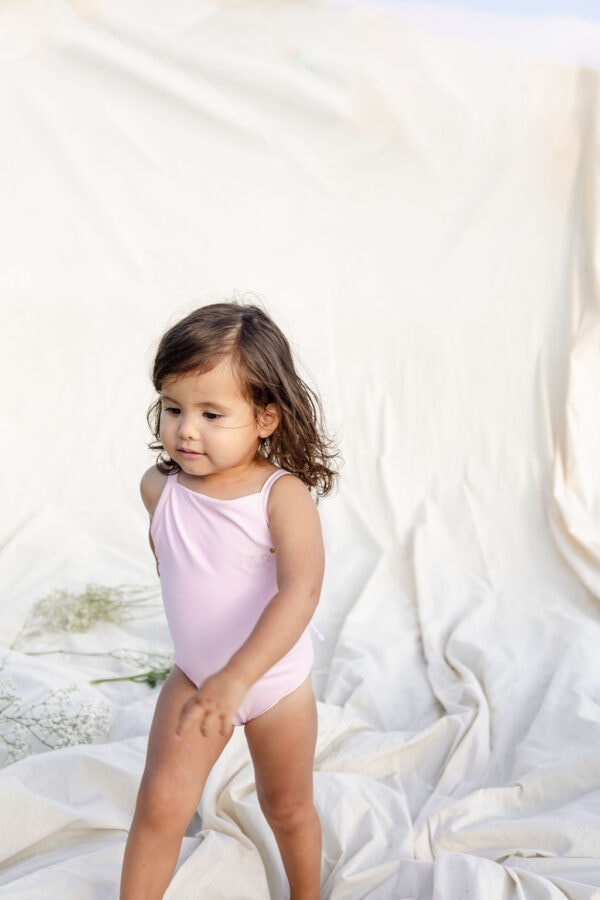 A little girl wearing a WS - Golden Meadows Collection - Mara One-Piece swimsuit.