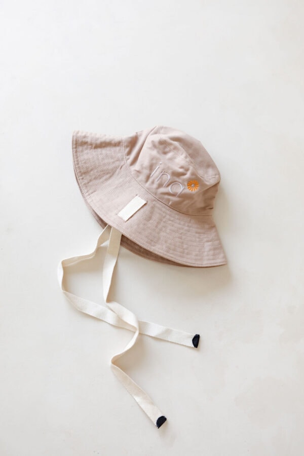 WS - Golden Meadows Collection - Golden Sun Bucket Hat with a white ribbon on it.