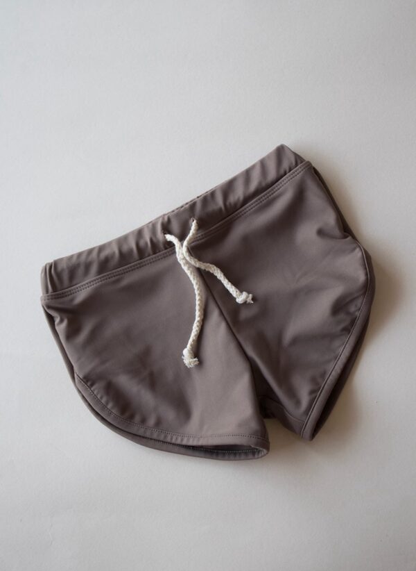 A pair of Essentials Range - Mesa Trunks - Tort Colour swim shorts on a white surface.