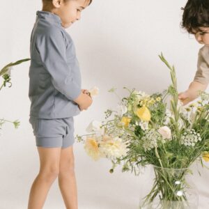 Two young boys playing with the Essentials Range - Nella Rash Shirt - Mineral Colour in a vase.