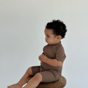 A baby sitting on a Essentials Range - Zimmi Onesie - Tort.