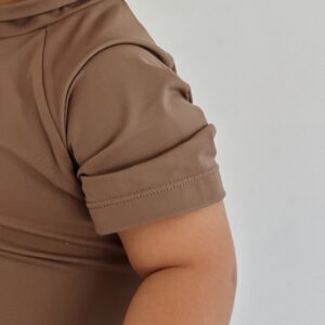 A baby wearing a brown Essentials Range - Zimmi Onesie - Tort shirt.